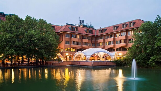 A hotel with a courtyard, a fountain, and a covered outdoor seating area.