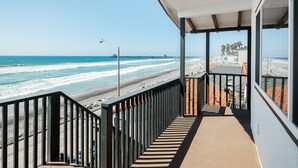 Un balcon avec vue sur la plage et l’océan.