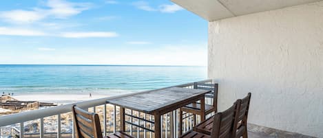 A balcony with a view of the beach and ocean.