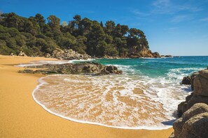 A beach with clear turquoise water, sandy shore, and rocky outcrops. - Bungalow Campground SOLMAR 200 m to the Mediterranean Sea (Blanes)