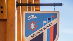 Une série de panneaux suspendus à une structure en bois, dont un pour l’école de ski et de snowboard de Stowe et un autre pour l’événement Stowe Rocks.