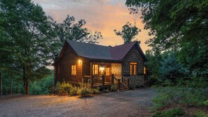 Eine Holzhütte mit Veranda, umgeben von Bäumen.