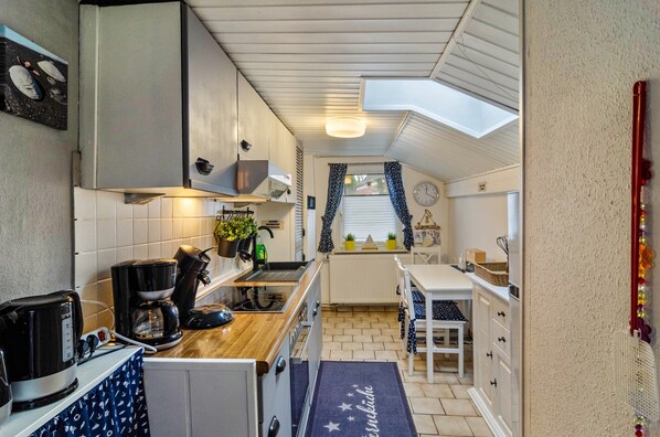 A compact kitchen with a coffee maker, a kettle, and a small sink.