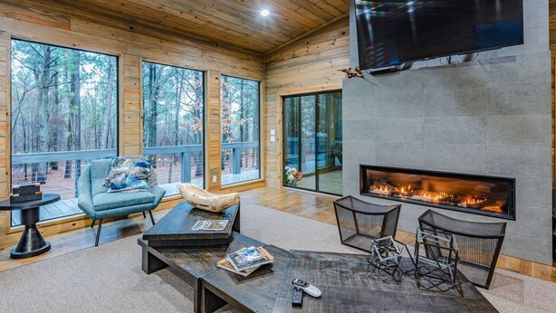 A spacious living area with a fireplace, large windows, and a cozy seating arrangement.