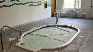 An indoor swimming pool with a tiled floor, a wall mural, and a seating area with chairs. - Ski, golf, hike or bike right outside your door if you like! (Kimberley)