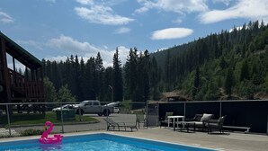 A swimming pool with lounge chairs and a wooden deck. - Ski, golf, hike or bike right outside your door if you like! (Kimberley)