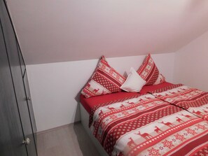 Ein Schlafzimmer mit einem Bett, Kissen und einer Tür.