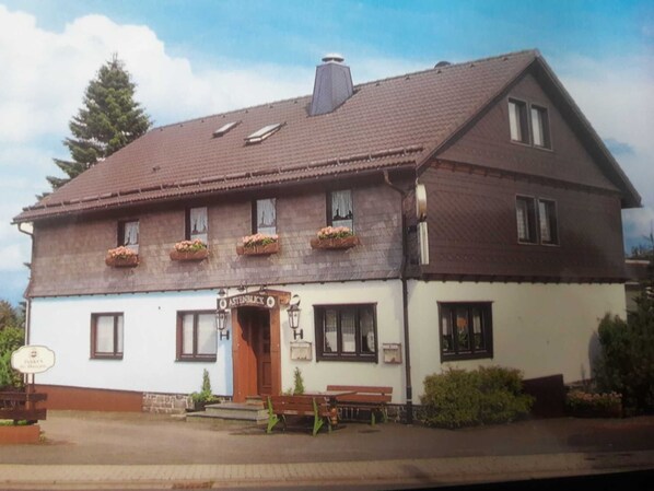 A two-story building with a sign reading 'ASTENBLICK.'