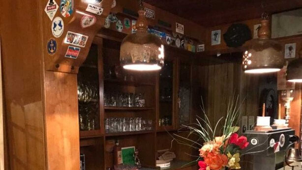 A bar area with wooden walls, a green countertop, and two stools. - Apartment Winterberg 7 persons - Guesthouse Astenblick also for small groups (Winterberg)