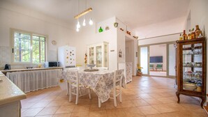 A spacious kitchen with a dining table, chairs, and a cabinet. - Villa Matilde, with swimming pool, whirlpool and pine forest, beach at 400m (Mazara del Vallo)