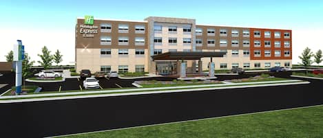 A Holiday Inn Express building with a parking lot, a covered entrance, and a landscaped area with flowers.