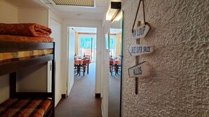 A narrow hallway with bunk beds on the left and directional signs on the right. - Studio cabin in Pra-Loup with balcony and mountain view (Pra-Loup)