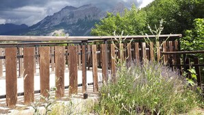 A wooden deck with a view of mountains and a forest. - Studio cabin in Pra-Loup with balcony and mountain view (Pra-Loup)