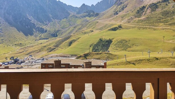 Un paisaje montañoso con un pequeño asentamiento y edificios en primer plano.
