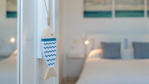A room with a bed, a nightstand, and a wall with three paintings.