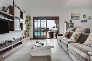A modern living room with a TV, flat-screen TV, and a coffee table.