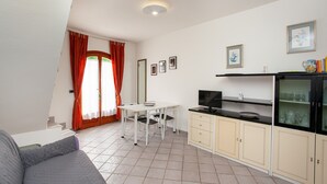 A compact living space with a kitchenette, a dining area, and a sofa.