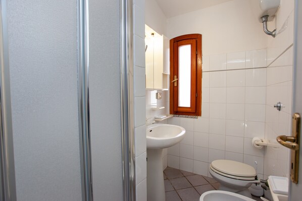 A bathroom with a toilet, sink, and mirror.