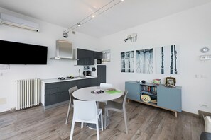 A modern kitchen with a flat-screen TV, a built-in microwave, and a gas stove.