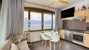 Une cuisine moderne avec un coin repas, de grandes fenêtres et une vue sur la mer.