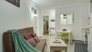 Una sala de estar moderna con un sofá, una mesa de comedor y una zona de cocina.