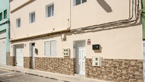A building with a stone facade, a white door, and a sign indicating a fire alarm. - Apartment “2A Francesca” close to the Sea with Wi-Fi & Fans (Vecindario)