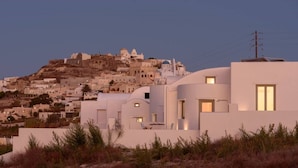 A coastal town with white buildings, some with domed roofs, and a hilltop with structures. - Salty villa with private Pool & Sea view (Santorini)
