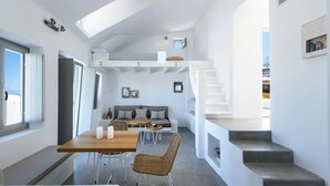 A modern interior with a dining area, sofa, staircase, and a view of the outdoors. - Sandy villa with private pool & Sea view (Santorini)