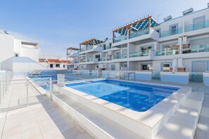 A modern hotel with a large outdoor swimming pool, multiple balconies, and a clear blue sky. - Apartment in condominium with pool 700m from the beach by AlgarveManta (1T3) (Manta Rota)