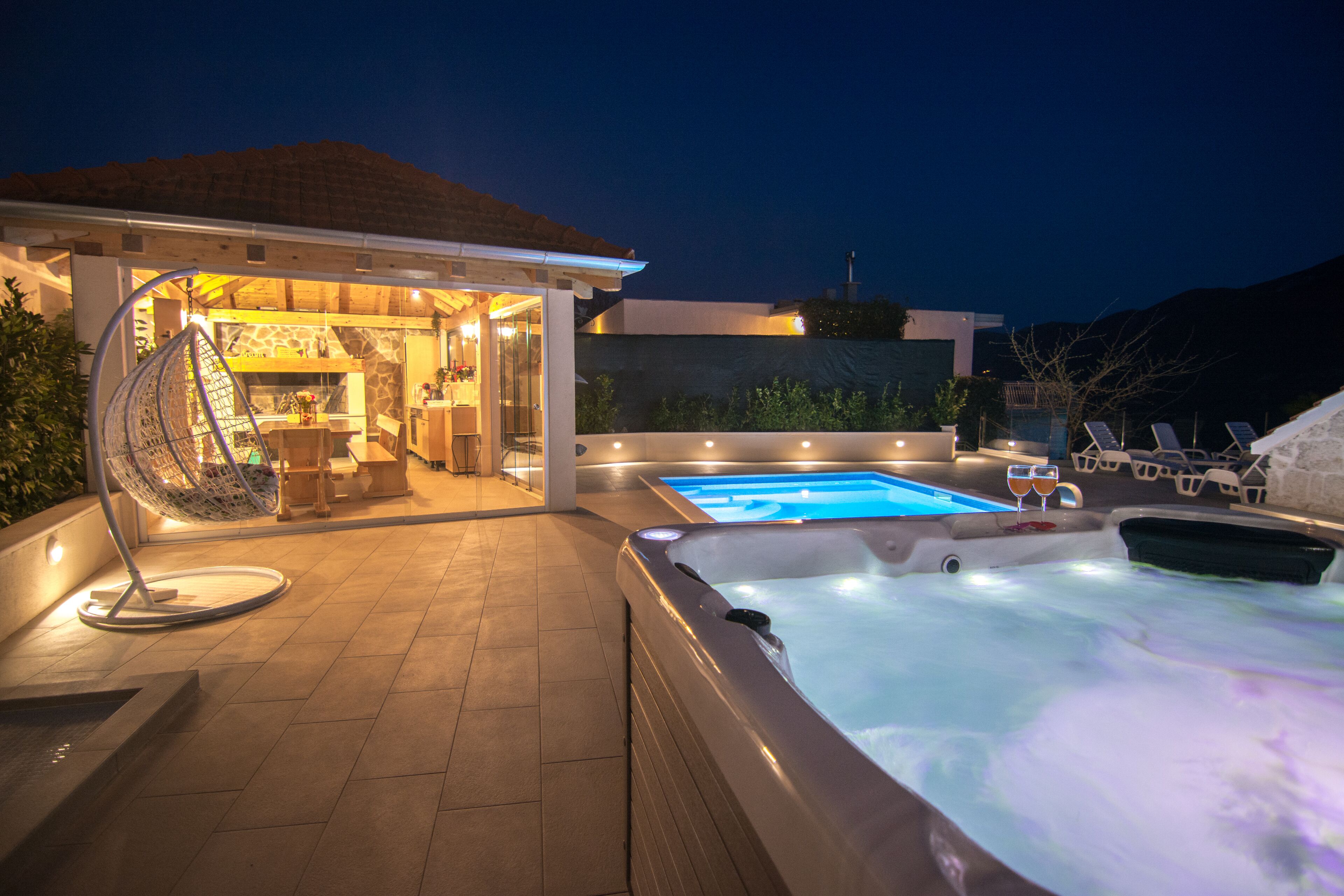 A hot tub, a pool, and a covered outdoor area with seating.