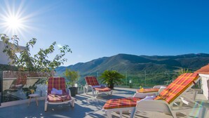 Eine Terrasse mit Liegestühlen und Bergblick.