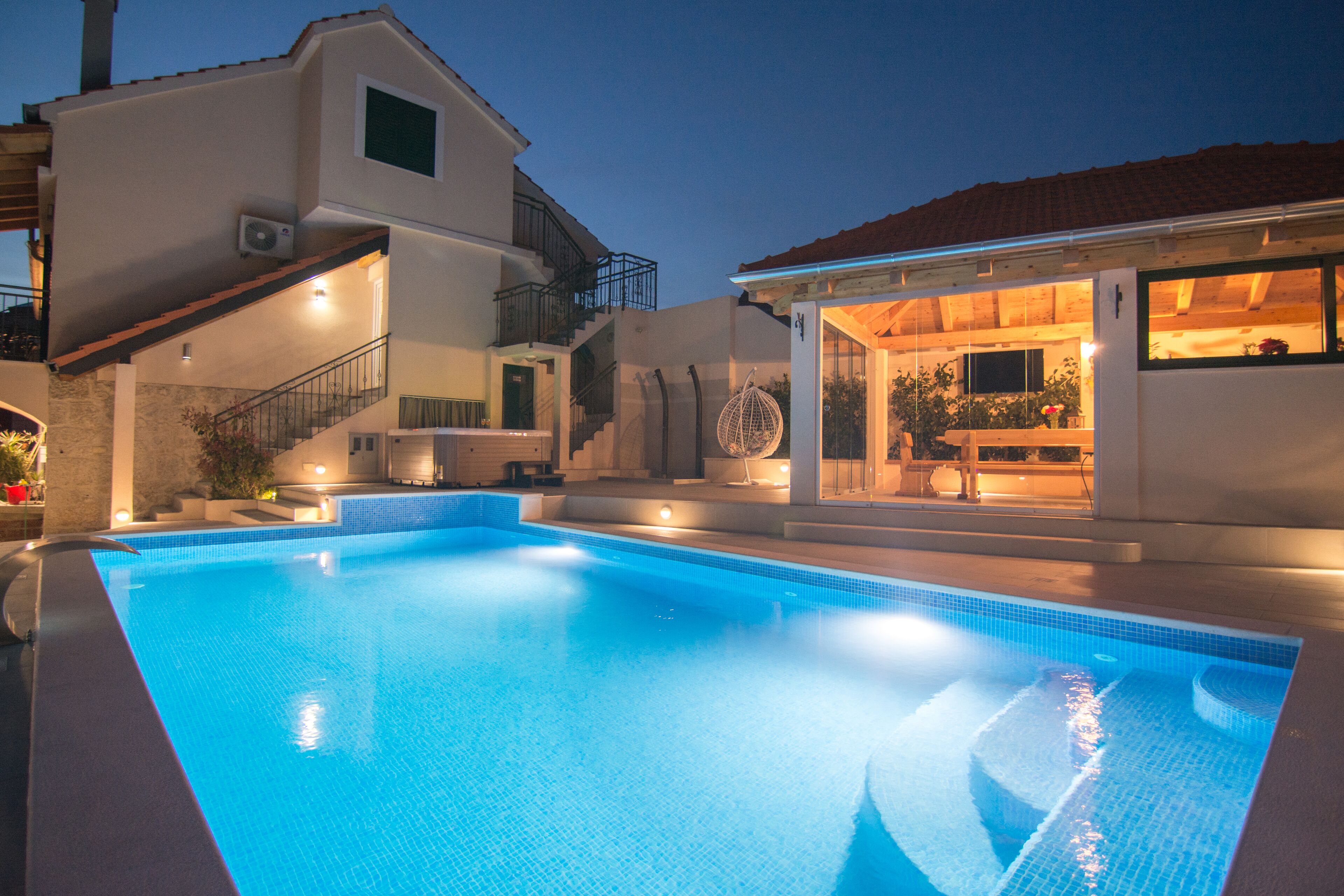 Una piscina con una casa moderna al fondo.