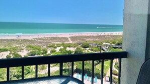A balcony with a view of a beach and ocean. - Seaview Oasis: Beachfront + Resort Access (Fernandina Beach)