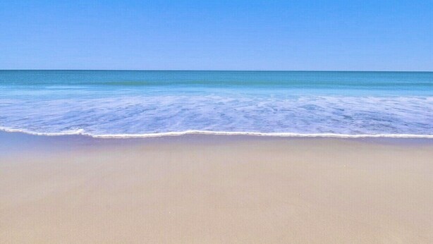 A beach with clear blue water and a sandy shore. - Seaview Oasis: Beachfront + Resort Access (Fernandina Beach)