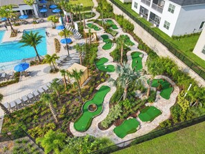 A golf course with a swimming pool and lounge chairs. - Family Disney Retreat / Entertainment Room / Console Provided (Kissimmee)