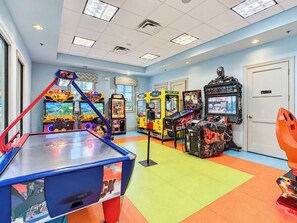 An indoor arcade with various gaming machines, a pool table, and a door.