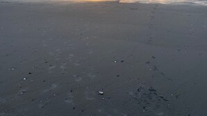 A beach with a sunset over the ocean.