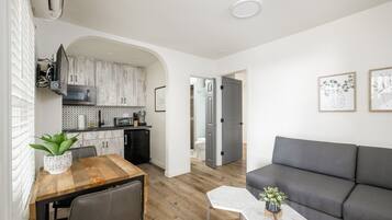 A modern apartment with a dining area, kitchen, and living room.