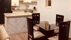 Una cocina moderna con una isla central, sillas de madera oscura y un ventilador de techo.