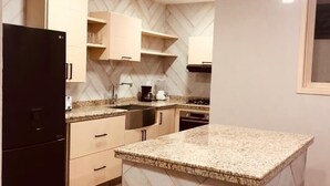 Una cocina moderna con una isla central, armarios empotrados y salpicadero con patrón de espiga.