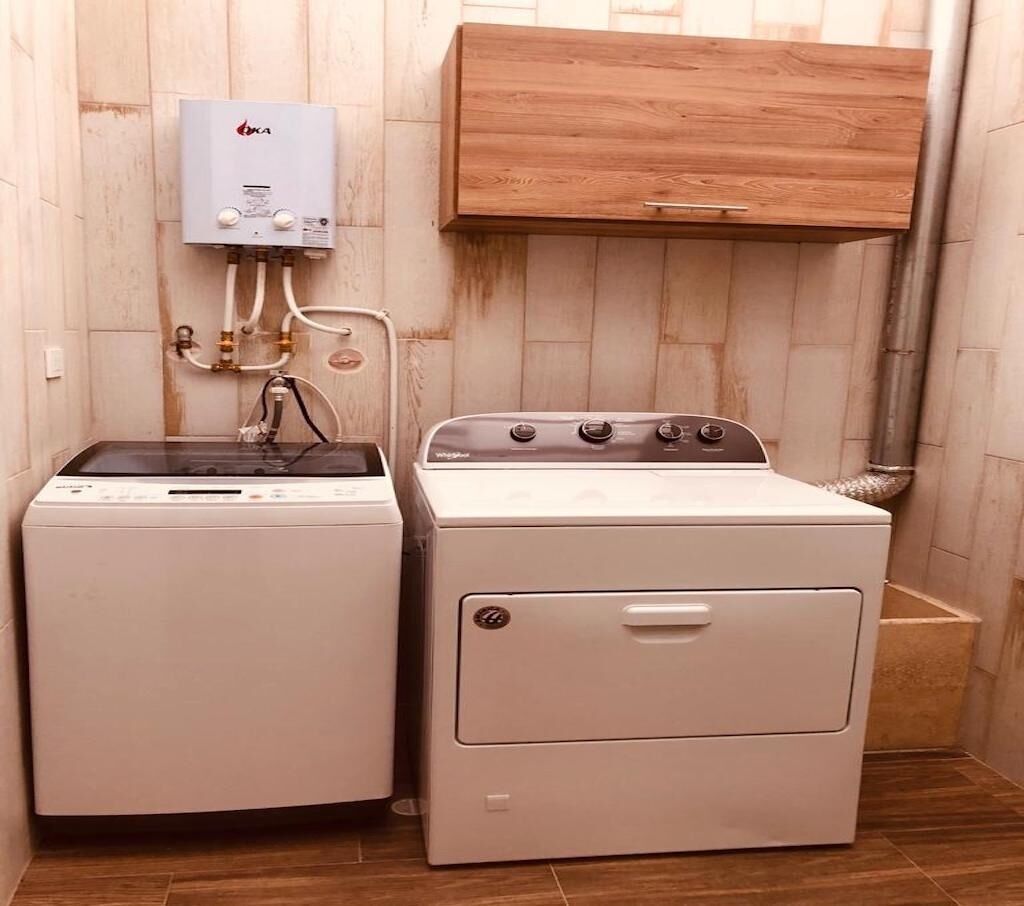 A laundry room with a washing machine, dryer, and a water heater.