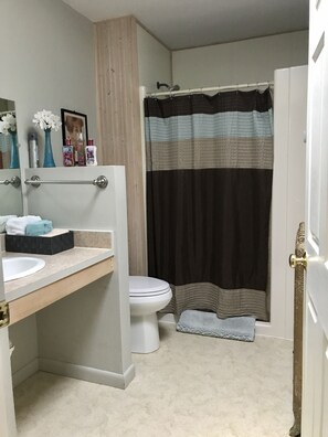 A bathroom with a toilet, sink, and shower curtain.