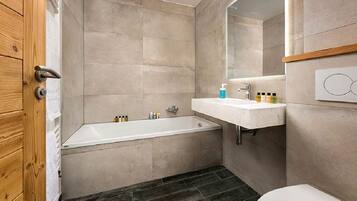Bathtub, hair dryer, towels, toilet paper