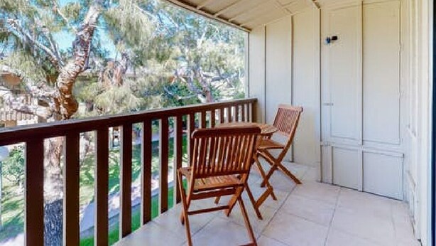 A balcony with wooden chairs, a white door, and a view of trees. - Palm Desert Condo. Near Tennis Gardens, Public Golf, Dog Park. EZ on the wallet! (Palm Desert)