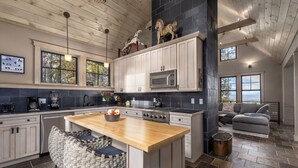 A spacious kitchen with a central island, modern appliances, and a cozy seating area with a view. - Modern Home with Mountain Views, Hot tub, Pool Table, and Gourmet Kitchen. (Tryon)