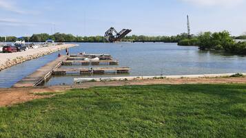 A marina with boats docked, a grassy area, and a water channel.