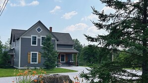 A two-story house with a grey exterior and a front porch.