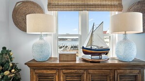 Een houten console tafel met twee getextuurde lampen en een model zeilboot.