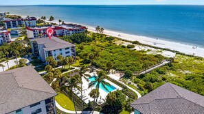 A resort with a swimming pool, beachfront, and multiple buildings.