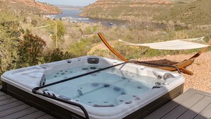 A hot tub on a wooden deck with a view of a river and hills. - Reservoir Retreat with Hot Tub and Mtn. Views! (Fort Collins)
